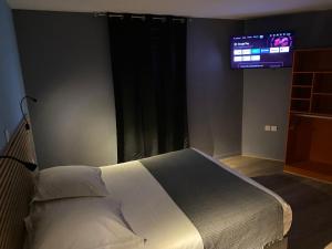 a bedroom with a bed and a tv on the wall at Royal Haveli in Tergnier