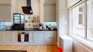 a kitchen with white cabinets and a counter top at The Dulwich in Cheltenham