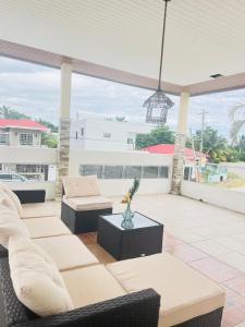 a patio with couches and a pendant light at Maximum Beach Hotel in Corozal