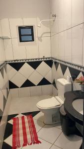 a bathroom with a toilet and a sink at Casa aconchegante e espaçosa in Palmas