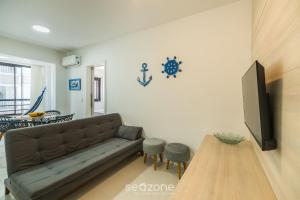 a living room with a couch and a tv at Apto c/ Churrasqueira 450m da Praia PNM0202 in Florianópolis