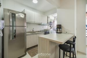 a kitchen with a stainless steel refrigerator and a counter at Apto c/ Churrasqueira 450m da Praia PNM0202 in Florianópolis +10 photos
