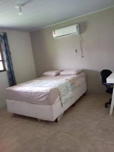 a bedroom with a bed with a air conditioner on the wall at Casa Amarela in São Francisco do Sul