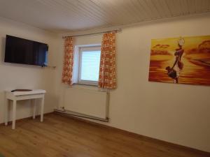 a living room with a tv and a window at Ferienwohnung Juna in Uttendorf