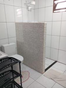 a bathroom with a toilet and a tiled shower at Casa Amarela in São Francisco do Sul