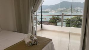 a bedroom with a bed with a view of the water at Apartamentos com vista para o Mar - Mirante do Marinas in Angra dos Reis