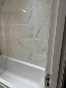 a bathroom with a shower with white marble walls at The City Glasgow in Glasgow