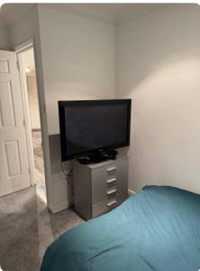 Un dormitorio con un televisor de pantalla plana y una cama. en The City Glasgow, en Glasgow