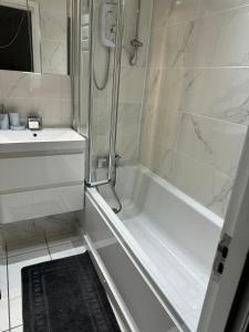 Un baño blanco con ducha y lavabo. en The City Glasgow, en Glasgow
