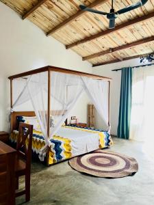 a bedroom with a bed with a canopy at Appartement YLANG in Hell-Ville