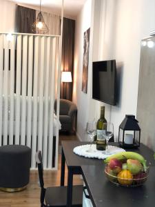 una camera con tavolo, cesto di frutta e bicchieri da vino di Studio apartman DORIS a Slavonski Brod