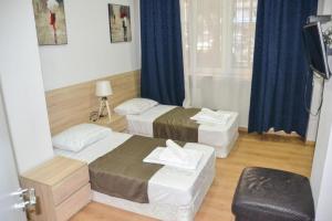 a hotel room with two beds and a window at Piccolo casa bella in Tbilisi City