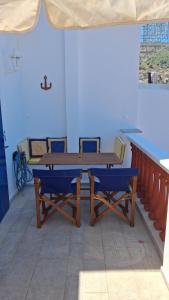a wooden table and two blue chairs on a patio at Villa Hydra Estrella in Hydra +16 photos