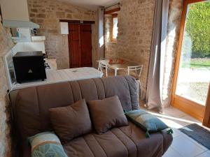 a living room with a couch and a table at ESCALE AU CLOS SAINT MARTIN DE JUILLERS Gîtes et Chambres d'hôtes in Saint-Martin-de-Juillers