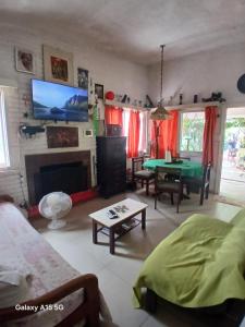 un soggiorno con camino e TV a parete di Casa en Pintoresco balneario/Punta Colorada a Punta Colorada