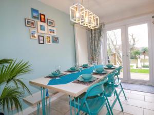 a dining room with a table and blue chairs at Estuary View in Newquay
