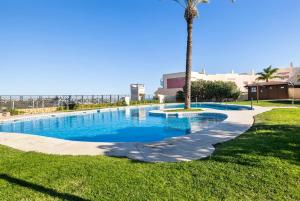 una piscina con una palmera y una acera en Casa Feliz Penthouse by Mabiente Properties, en La Cala de Mijas