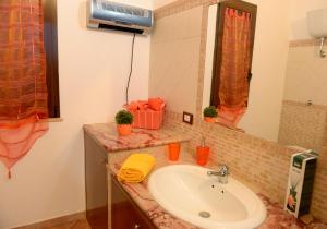 ein Badezimmer mit Waschbecken und Spiegel in der Unterkunft Villa Pergola in San Michele Salentino + 33 Fotos
