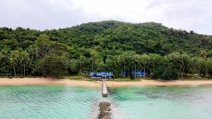 a boat in the water next to a beach at DK2 Resort - Hidden Natural Beach Spot - Direct Tours & Fast Internet in El Nido