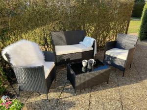 three wicker chairs and a table with at Ferienwohnung Idylle auf Fehmarn II in Vitzdorf