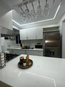 a kitchen with white cabinets and stainless steel appliances at Santo Domingo Este Stylish Condo in San Isidro