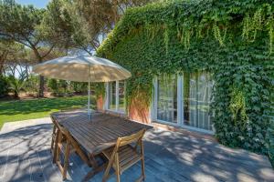 a wooden table with an umbrella on a patio at Quinta da Bicuda in Cascais