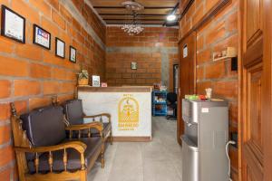 a room with chairs and a sign in a brick wall at HOTEL EMBRUJO CAMPESTRE in Jardin