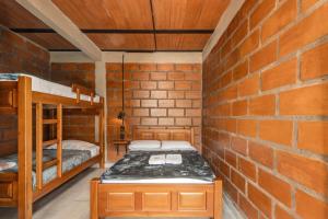 a room with two bunk beds and a brick wall at HOTEL EMBRUJO CAMPESTRE in Jardin
