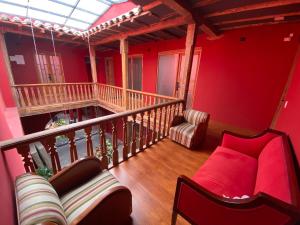 a living room with red walls and a couch at Apartaestudio comodo y central S4 - WiFi in Pasto