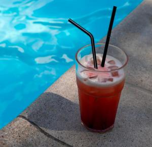 a drink in a glass next to a swimming pool at Safari-Club in Vinnytsya