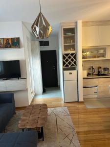 a living room with a blue couch and a kitchen at Apartman 10 in Zlatibor