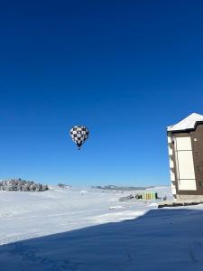 a kite flying in the sky next to a building at Apartman 10 in Zlatibor +9 photos