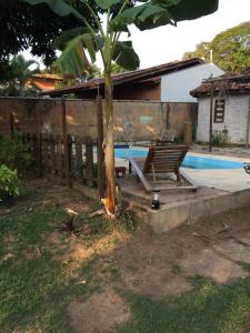 a bench sitting next to a tree next to a pool at divino aconchego unicamp in Campinas