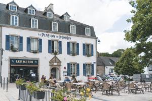 阿旺桥Logis Hôtel et Restaurant La Pension du Moulin的一座前面有桌椅的建筑物