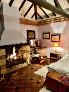 un salon avec une cheminée et un lit dans l'établissement Villa exclusiva con jardín a 80m del centro, à Villa de Leyva