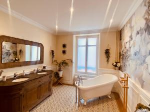a bathroom with a tub and a large mirror at La Villa Alma Colmar in Colmar