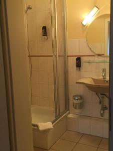 ein Bad mit einer Dusche und einem Waschbecken in der Unterkunft Hotel Imperial in Hamburg