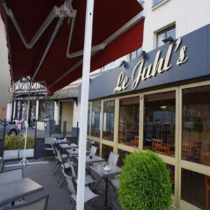 un restaurant avec des tables et des chaises à l'extérieur d'un bâtiment dans l'établissement Hotel De Rouen, à Louviers