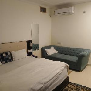 a bedroom with a bed and a couch in it at Entire apartment khajuraho in Khajurāho