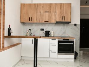 a kitchen with white counters and wooden cabinets at Apartman Ruzica in Trebinje