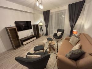a living room with a couch and chairs and a television at Lovely cozy apartment - Cahul in Cahul