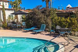 a swimming pool with chairs and a table and an umbrella at The Frey in Palm Springs