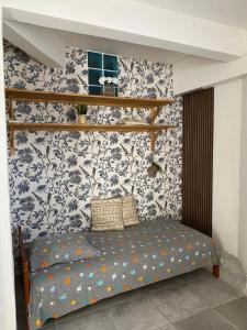 a bedroom with a bed with blue and white wallpaper at Maison cosy avec terrasse à Le Gosier 40 m² in Le Gosier