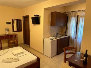 ein Zimmer mit einem Bett und eine Küche mit einem Tisch in der Unterkunft VILLA ELENI in Skala Marion