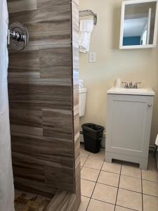 a bathroom with a wooden shower door with a sink at Shore Point Motel in Point Pleasant Beach