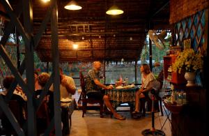 a group of people sitting at a table in a restaurant at BOSA Homestay - Mekong Riverside in Can Tho