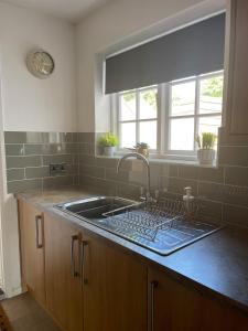 a kitchen counter with a sink and a window at Cozy two bedroom home with historic significance in Saint Neots