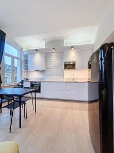 a large kitchen with white cabinets and a table at Cosy Apartment Uccle 3 in Brussels