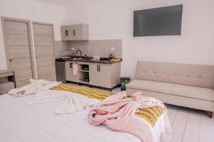 a room with a bed and a kitchen with at The Madevelyn in Atitlán in Panajachel