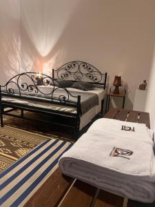 a bedroom with two twin beds and a rug at Villa Mariem in Tozeur